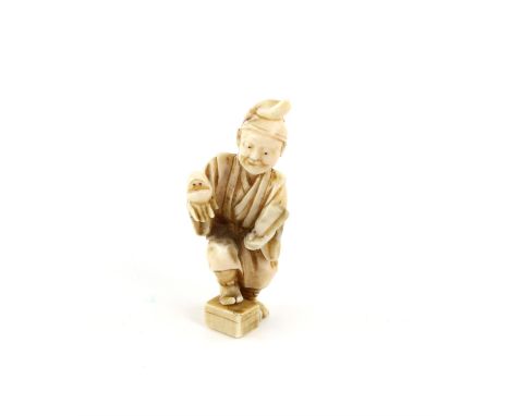 A Japanese Okimono , Meiji Period Circa 1880 Carved Ivorydepicting a man holding a bird and a fan with figures. Signed ..6.1 