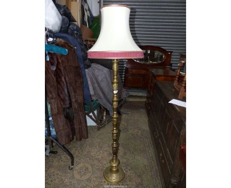 A brass based Standard Lamp with cream and maroon shade.