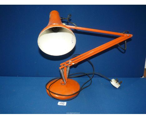 An orange angle poise lamp.