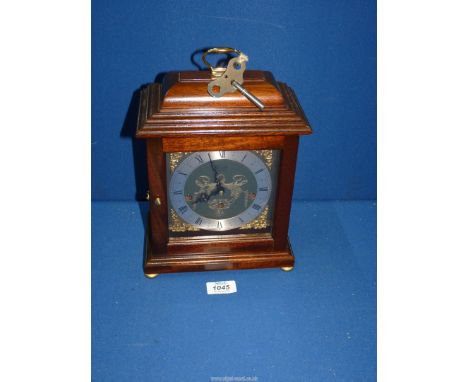 A Comitti of London Mahogany style bracket Clock with silvered chapter ring, Roman numerals, pierced spandrels, engraved bras
