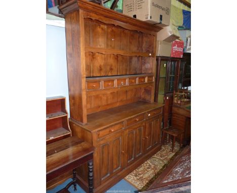 A medium Oak Dresser, the base with three double panel doors with three frieze drawers over, the enclosed back rack having si