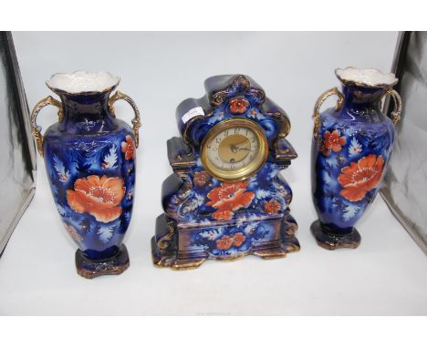 An elegant porcelain Clock Garniture decorated with dusky pink Chrysanthemum type flower blooms against a blue over white pow