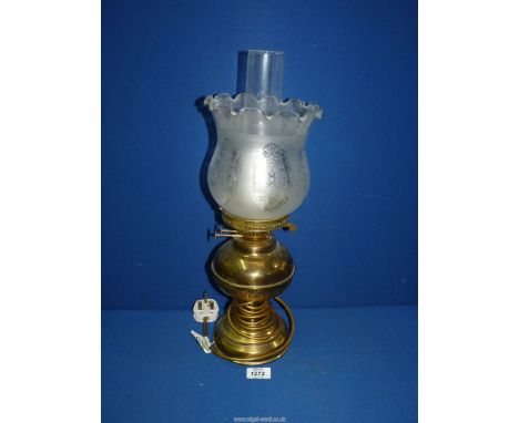 An oil lamp converted to electric with brass base and reservoir and etched glass shade, 19" tall.