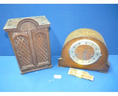 A dark wood cased mantle clock (damage to side) and a small darkwood cupboard with lattice design doors.  