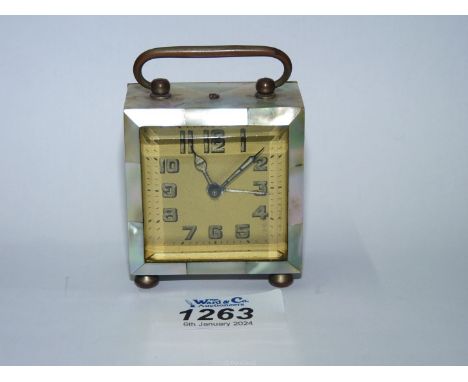 A pretty carriage clock of small proportion encased with Mother of Pearl and having bevelled edge glass to the face which has