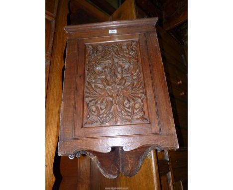 An Oak wall hanging Corner Cupboard, the door intricately carved with intertwined serpents, 29'' high x 19 1/2'' wide, the in