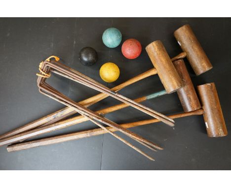 A vintage lawn croquet set to include four mallets, four balls and five hoops. 