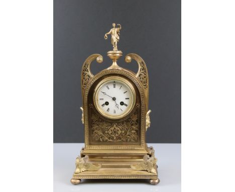 An early 20th century brass and gilt decorative mantle clock with chining movement, finial of female in classical form with o