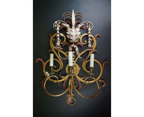 A gilt metal four branch wall lamp sconce with floral decoration.