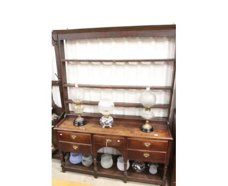 18th century Oak Welsh Dresser, the open plate rack with three shelves above a base with central arch, an arrangement of four