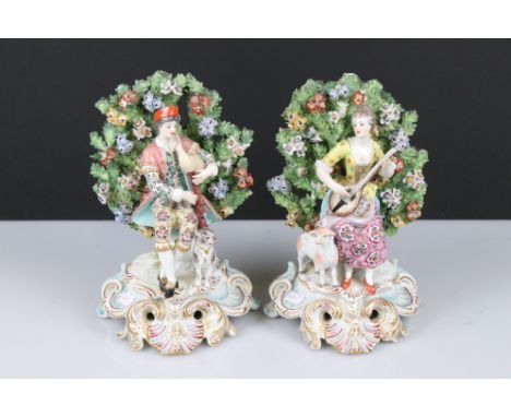 Pair of Chelsea Porcelain Bocage Figures in the form of a Man playing bagpipes with a dog and a Woman playing a lute with a s