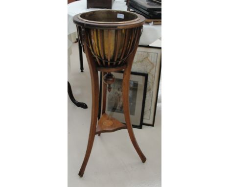 An Edwardian jardinere stand with brass insert on tripod legs