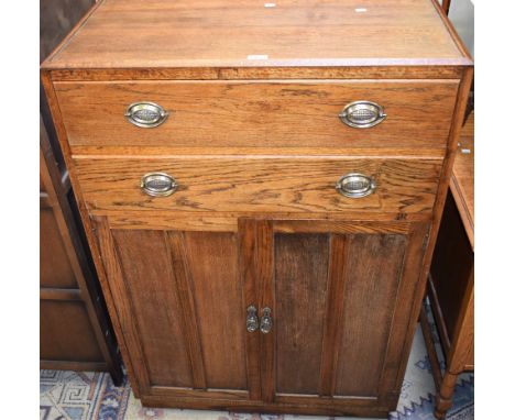 A 1930's oak 'tallboy', two long drawers above a pair of cupboard doors enclosing a shelf, 127cm high