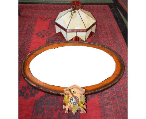 A heptagonal stained glass lamp shade/light fitting; a cuckoo clock; an oval oak framed bevelled mirror (3)