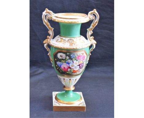 An English porcelain pedestal two handled vase, well painted with flowers in a gilt octagonal panel on an avocado green groun