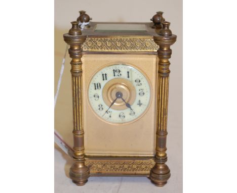 An early 20th century French lacquer brass carriage clock having turned reeded columns and white enamel chapter ring