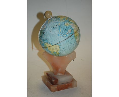 A lithograph printed metal globe on onyx plinth