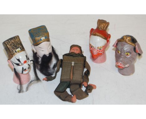 Four oriental puppet heads, together with a novelty matchbox holder 