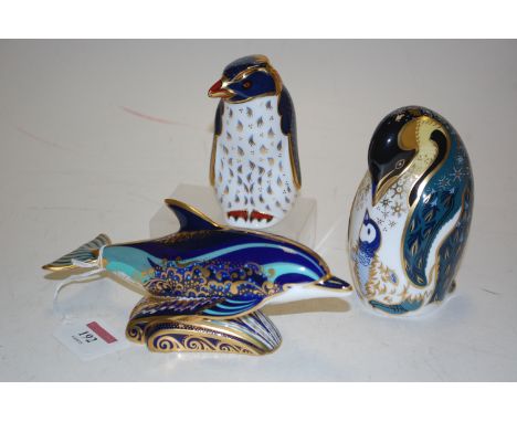 Three Royal Crown Derby desk ornaments, bottle nosed dolphin, rock hopper penguin, and emperor penguin, all with gold stopper