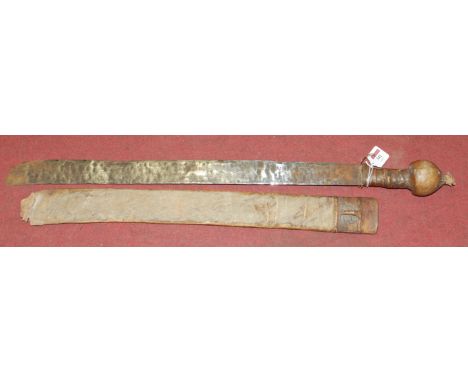 A 20th century tribal machete having hide covered handle in a hide covered sheath