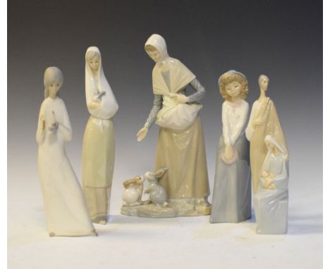 Lladro figure group, together with three Nao figure groups and a bisque glazed figure of a girl with chamberstick, the talles