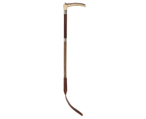 AN EDWARDIAN GENTLEMAN'S HUNTING CROP with antler handle, silver hallmarked collar, leather grip and plaited leather shaft, b