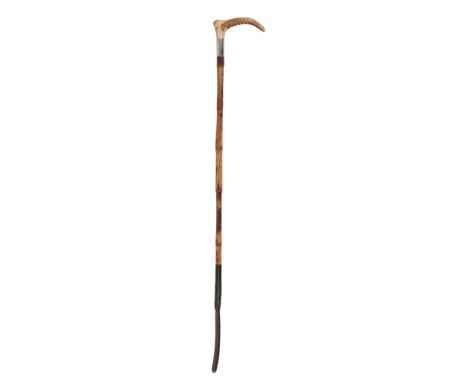 AN EDWARDIAN GENTLEMAN'S HUNTING CROP with antler handle, silver collar with hallmarks and ribbed bamboo shaft, by George Sch