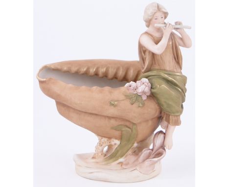 A Royal Dux vase,
modelled as a shell surmounted by a figure of a girl playing a flute, height 11".