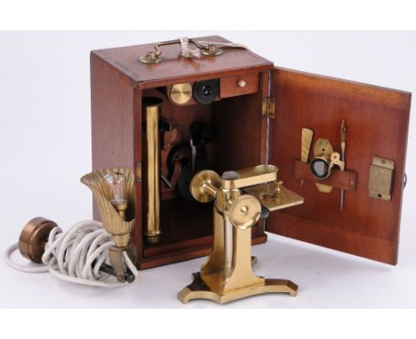 A brass student's microscope and accessories,
in walnut case by Cary of London, and a brass lamp.