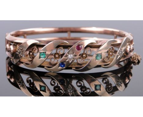 A Victorian unmarked gold hinged bangle,
set with multi-coloured gemstones, gross weight 11.5g.
