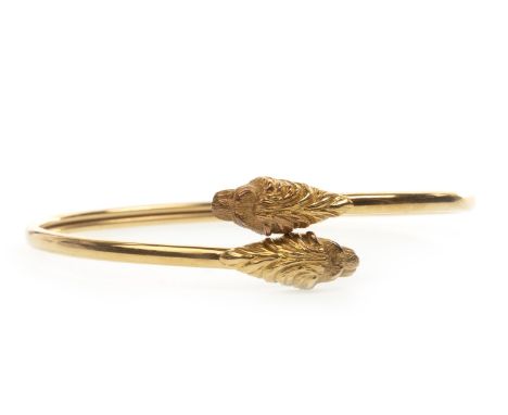 GOLD LION MOTIF BANGLE, the ends modelled as lions heads, 59mm inner diameter, in eighteen carat gold, 10.8g
