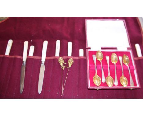 A set of six silver backed and mother-of-pearl handled knives and forks, together with a cased set of six teaspoons, each wit
