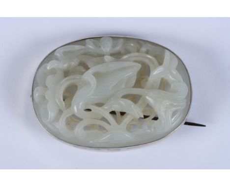 A Chinese lotus carved jade oval brooch with silver mount, 2 1/4" max diacondition: condition appears to be good with no visi