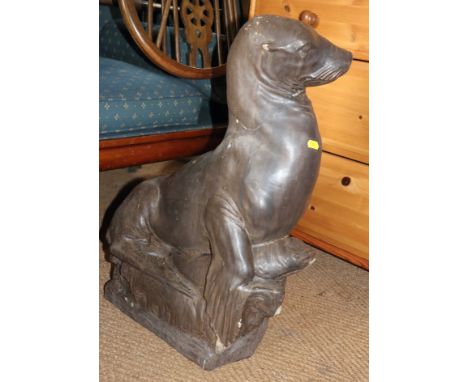 A bronzed glazed ceramic garden model of a sealion with a fish, 26" high (damages)