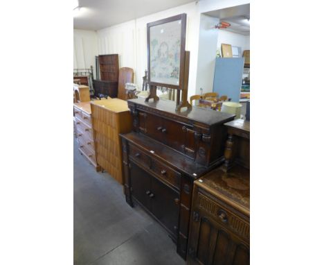 A carved oak court cupboard and an embroidered firescreen 