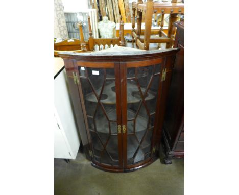 A George III mahogany bow front hanging corner cupboard 