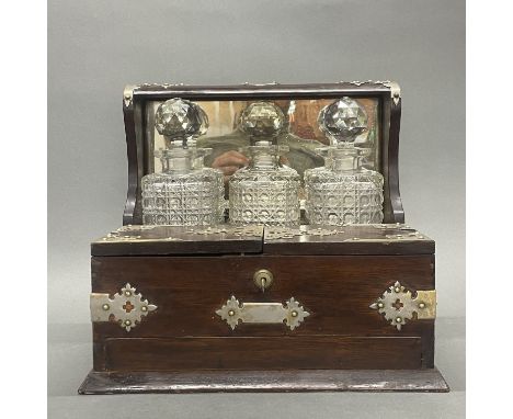 A three bottle antique tantalus with hobnail cut decanters (all appear to be in good order), W. 36cm.