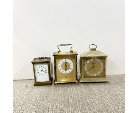 A brass carriage clock with two further quartz clocks.