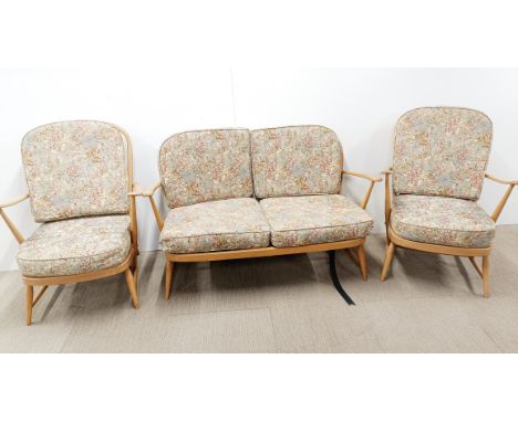 A mid century Ercol blonde elm three piece suite comprising of two armchairs, and two seater settee/sofa, all with original c
