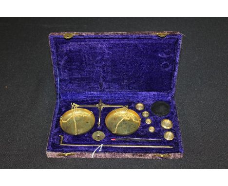 Set of brass balance scales and weights, housed in a blue velvet lined case