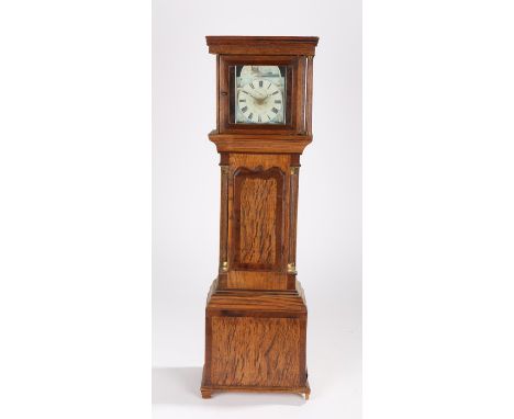 Oak cased miniature longcase clock, the square hood above a shaped trunk door and quarter columns above a panel base, with an