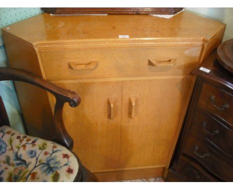 A circa 1960's light oak G-plan corner cupboard, having frieze drawer above a pair of cupboard doors on plinth.