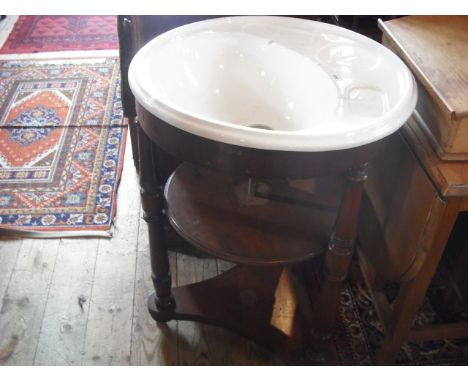 A white ceramic circular wash basin on an associated three tier support.