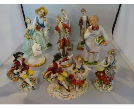 Nine Continental porcelain figures, including: a pair of Naples figures of a young man and lady, each stood beside a stone co