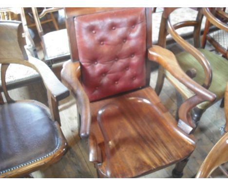 A mahogany framed gentleman's club chair with button hide upholstered back, solid seat, on heavy turned tappering supports un