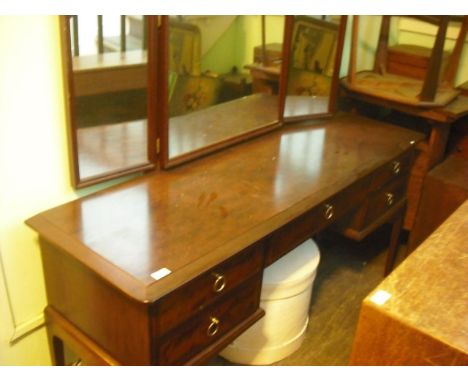 A stag dressing table with triple mirror above an arrangement of five drawers on square tapering supports.