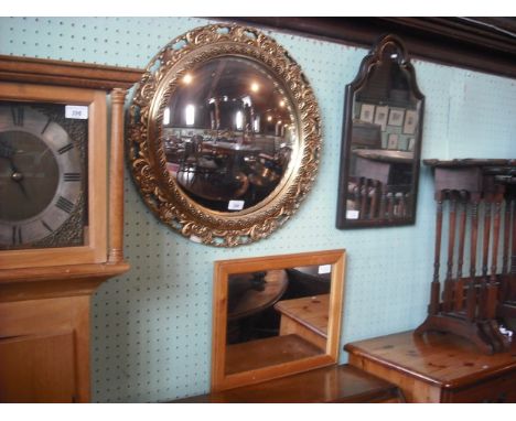 A gilt composite circular wall mirror with convex plate, together with a cushioned framed wall mirror and a modern pine wall 