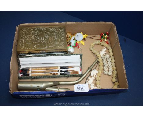 An Oriental brass cigarette box, a boxed set of three paint brushes, an opium pipe, carved beads, etc.,