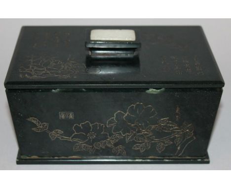 A CHINESE HARDSTONE BOX & COVER, the finial with an inset jade-like plaque, the flaring sides and cover incised with foliage,