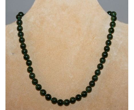 A CHINESE SPINACH-GREEN JADE-LIKE NECKLACE, with a 9k gold clasp, approx. 16.3in long.